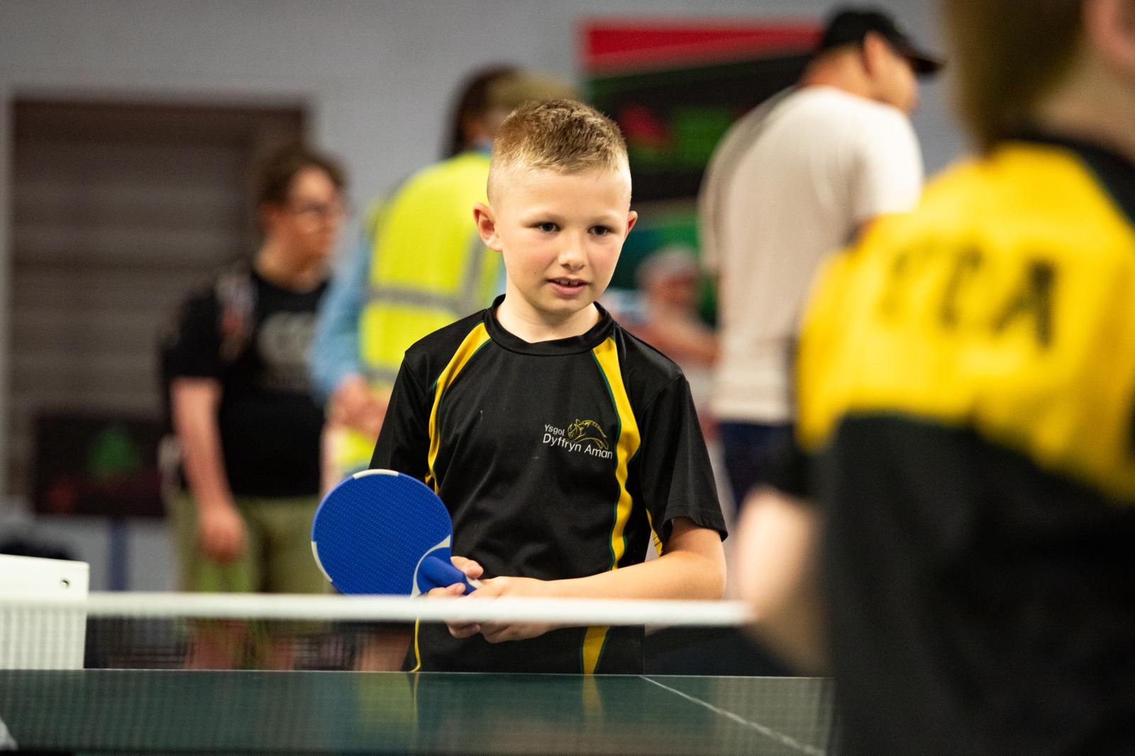 A young boy listens to instructions during a para table tennis session