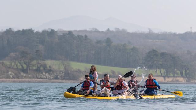 A group of kayakers enjoy a trip on the Menai Strait