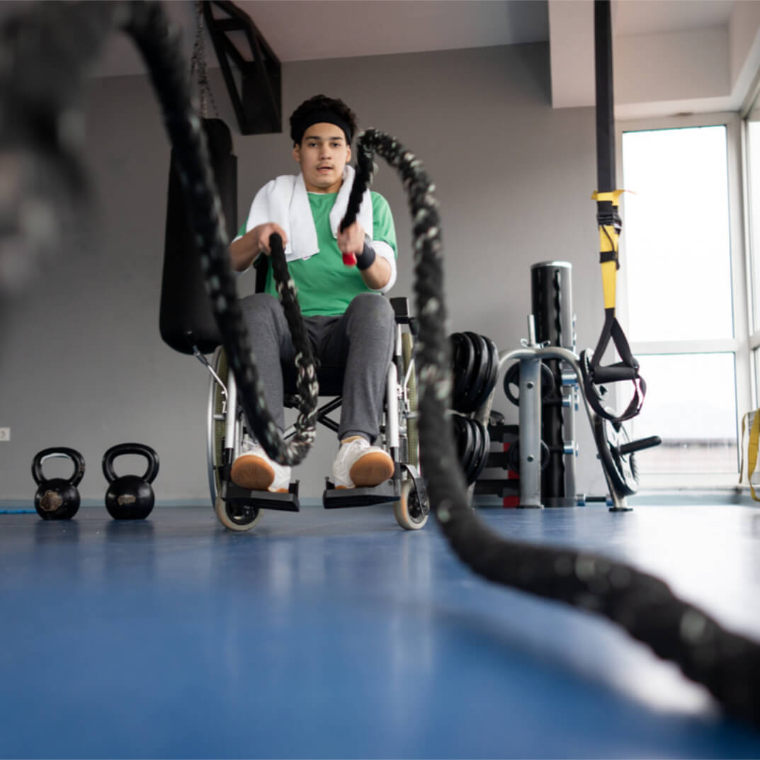 A wheelchair user does strength training with battle ropes