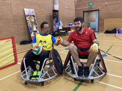 A coach and participant playing wheelchair rugby
