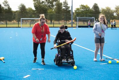 A powerchair user enjoys adapted hockey drills